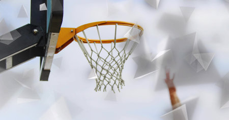 Showing basketball hoop orange rim and net on black support arm at outdoor court, orange wristband. Sports equipment, athletic, urban, minimalist, high energy, fitness, motivationの写真素材