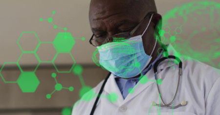 Doctor wearing mask, glasses, stethoscope, lab coat analyzing green molecular holograms in clinic. Medical, healthcare, science, innovation, professionalism, research, technologyの写真素材