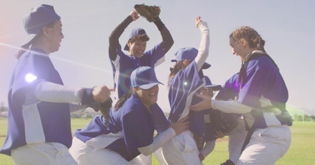 Celebrating baseball players at sports field, with baseball gloves, caps, jerseys and white pants. Team, camaraderie, accomplishment, outdoor, joyful, athletic, vibrantの写真素材