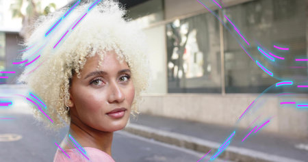 Standing woman flaunting curls on sidewalk by glass building, palm trees, neon purple, blue streaks....