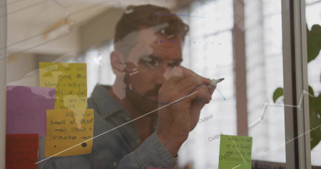 Senior male sketching rising curve on clear board in office, with colored sticky notes and marker. Corporate, innovation, brainstorming, minimalist, productivity, business, workspaceの写真素材