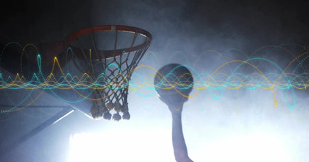Jumping silhouette wearing jersey reaching hoop on court, with basketball and waveforms. Dynamic, athleticism, performance, energy, movement, futuristic, graphiteの写真素材