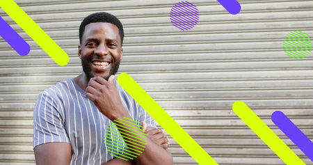 Smiling man in tee leaning on storefront shutter, with neon green-purple overlay shapes, copy space....