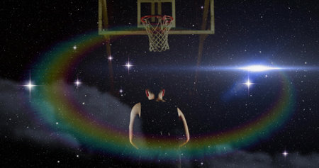 Standing man wearing jersey gazing toward floating basketball hoop in starry sky with lens flare....