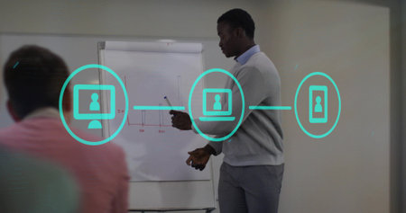 Presenting man in sweater explaining flipchart graph in boardroom with marker, floating call icons....