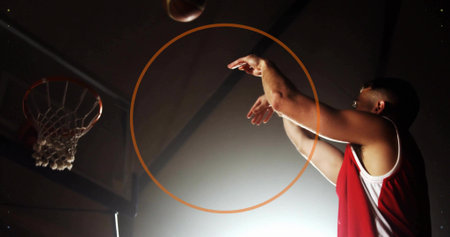 Jumping male in jersey shooting basketball at gym, with hoop, net, backboard, copy space. Athlete, sports, action, dynamic, intensity, competition, fitnessの写真素材