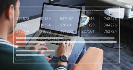 Typing man working on laptop in lounge on orange sofa, with floating code overlay, copy space. Technology, remote work, modern interior, digital, productivity, casual, innovationの写真素材