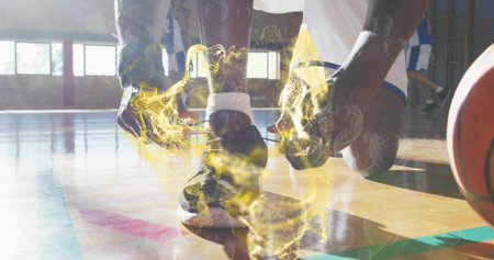 Basketball player in uniform tying laces on gym court, with glowing aura around shoe and basketball....