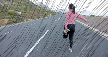 Stretching Asian woman in athletic gear pulling foot behind on mountain road, with cap and shoe. Fitness, outdoor, adventure, athletic, scenic, activewear, motivationの写真素材