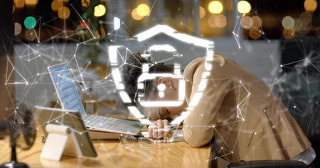 Leaning African American woman resting head on desk at office at night, with laptop, shield overlay. Technology, cybersecurity, innovation, businesswoman, modernoffice, professional, digitalの写真素材