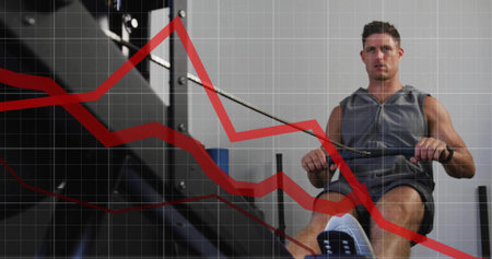 Man pulling handlebar on rowing machine inside gym, with red trend line grid overlay, copy space....