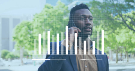 Analyzing professional in navy blazer talking on smartphone while viewing data overlay in plaza. Digital, urban, professional, modern, business, technology, analyticalの写真素材