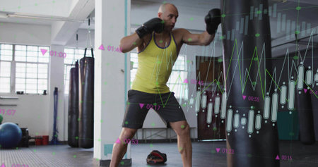 Boxer wearing neon tank top practicing punches on heavy bag inside boxing gym. Training, fitness,...