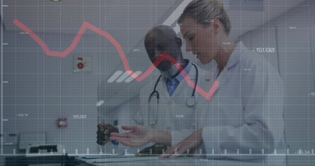Reviewing data doctors using touchscreen table in hospital corridor, stethoscope and red line graph....