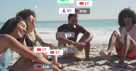 Laughing four friends interacting with floating notification icons on sand at water's edge, ocean....