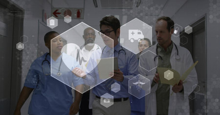 Walking team in scrubs reviewing patient records in hospital corridor, digital interface overlay. Medical, collaboration, healthcare, interface, clinical, diagnosis, professionalの写真素材