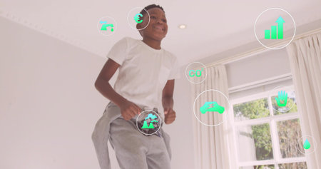 Boy in white tee, gray sweats interacting with digital icons at home by window, ceiling light....