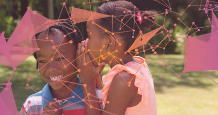 Whispering sister sharing secret with brother on sunlit lawn. Family, childhood, connection, outdoor, vibrant, playful, friendshipの写真素材
