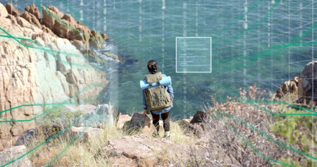Standing hiker wearing hiking boots on coastal cliff, with olive-green pack, blue sleeping pad. Adventure, exploration, wilderness, rugged, scenic, outdoor, natureの写真素材