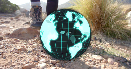 Floating neon-blue globe hologram hovering above rocky trail with leggings, hiking boots and grass. Technology, adventure, outdoor, futuristic, exploration, innovation, ruggedの写真素材