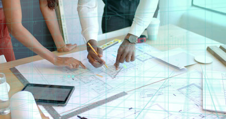 Pointing two architects leaning over wooden table in design studio, with blueprints pencil tablet....