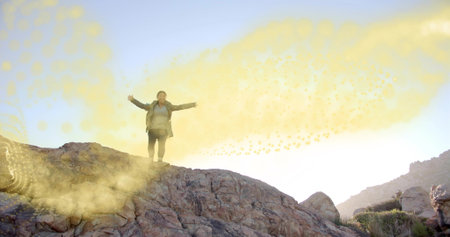 Hiking woman wearing trekking jacket, boots carrying daypack on rocky ridge, swirling golden effect....