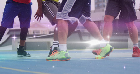 Defending players lunging on blue outdoor basketball court, with compression leggings. Athleticism,...
