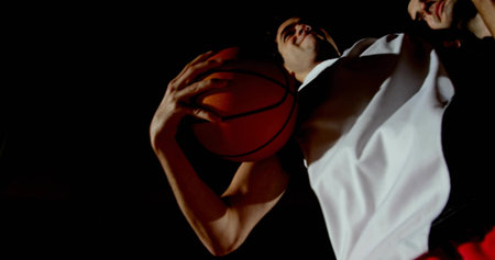 Holding basketball overhead, white-jersey player preparing dunk on basketball court, copy space. Athlete, sports, action, competition, gymnasium, dynamic, teamworkの写真素材