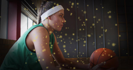Female athlete resting in jersey and headband on court bench, holding orange basketball, copy space. Sports, fitness, resilience, determination, minimalist, vibrant, athleticの写真素材