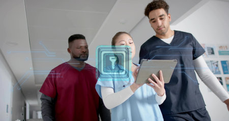 Walking three workers in scrubs viewing hologram security lock on tablet in hospital hall, security. Medical staff, healthcare technology, digital security, modern hospital, teamworkの写真素材