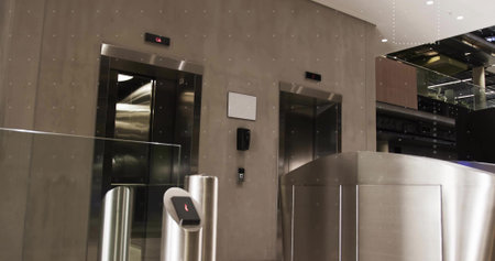 Featuring metal security turnstile controlling access at corporate lobby, with elevator doors....