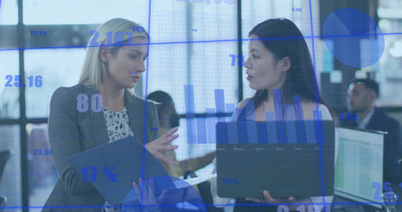 Analyzing two business professionals presenting data overlay at open office, with laptop and tablet....