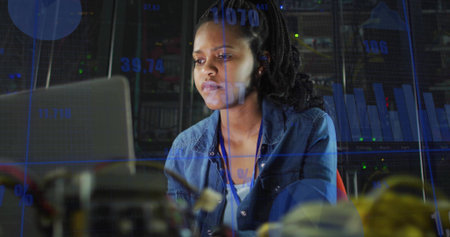 Female engineer analyzing data overlays and components in data center, with laptop and server racks....