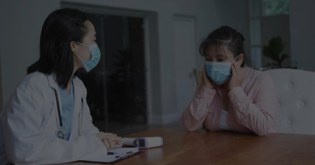 Doctor and patient exchanging information at consultation table, with stethoscope and clipboard. Medicine, healthcare, clinical, wellness, professionalism, examination, therapyの写真素材