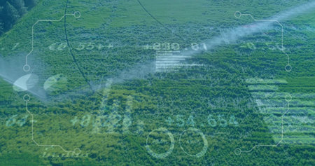 Spraying mobile sprinklers watering crop rows in rural farmland, with digital interface overlay....
