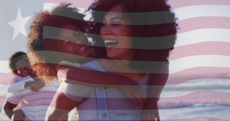 Carrying woman giving piggyback ride along sandy beach with waves at sunset. Family, coastal, sunset, diversity, leisure, unity, serenityの写真素材