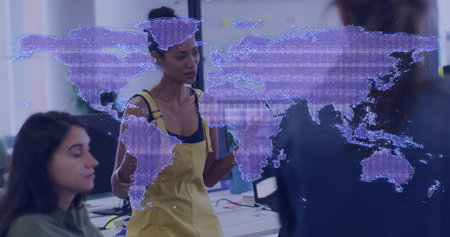Leading discussion woman in yellow overalls holding notebooks in workspace, with purple map graphic. Collaboration, innovation, technology, teamwork, digital, modern, communicationの写真素材