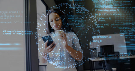 Woman wearing shirt scanning smartphone through glass partition in open office, coffee cup and code. Technology, innovation, workspace, digital, startup, modern, professionalの写真素材