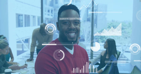 Smiling man wearing red sweater standing in office meeting room, with documents and coffee cup. Professional, collaborative, modern, interior, teamwork, innovation, communicationの写真素材