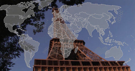 Capturing Eiffel Tower rising against sky in park framed by branches, with world map grid overlay....