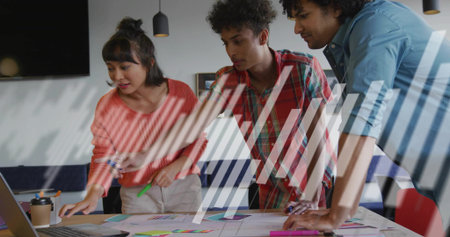 Pointing woman in sweater guiding team in office, with laptop, printed materials, coffee cup. Collaboration, strategy, brainstorming, teamwork, professional, modern, officeの写真素材