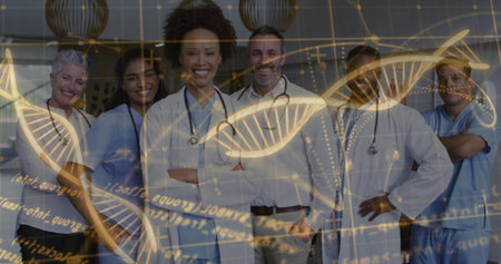 Standing team wearing white coats and scrubs in clinic hall, showing golden DNA helix overlay. Medical, teamwork, laboratory, research, innovation, healthcare, diagnosticsの写真素材
