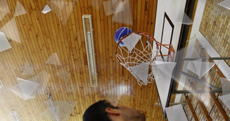 Featuring man watching basketball passing through hoop in gym with net and backboard, copy space....