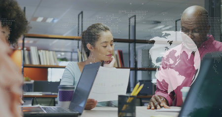 Woman in business casual attire analyzing report on laptop at office, with digital map overlay. Collaboration, strategy, innovation, professional, technology, teamwork, communicationの写真素材