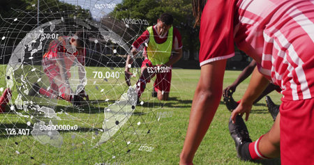 Stretching soccer players on grass field in park, with neon bib and digital globe overlay. Athletes, teamwork, fitness, outdoor, dynamic, exercise, vitalityの写真素材