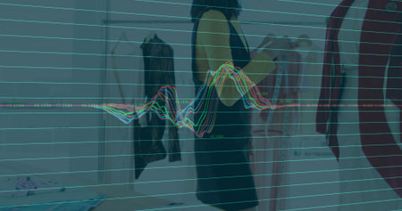 Scrolling adult Asian woman browsing options in boutique showroom, with tablet rack and mannequin. Retail, fashion, style, shopping, boutique, modern, vibrantの写真素材