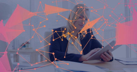 Holding tablet professional in navy blazer and white blouse at wooden desk, with network overlay. Technology, communication, teamwork, modernity, data, connectivity, innovationの写真素材