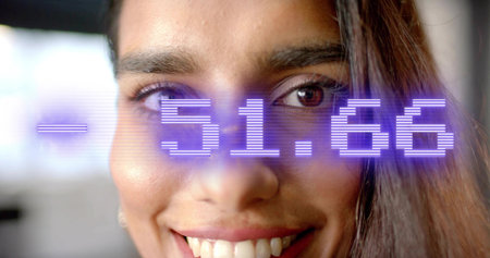 Smiling Indian woman displaying purple numeric overlay on face in office space, digital display. Technology, innovation, biometric, futurism, corporate, communication, minimalismの写真素材