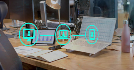 Displaying spreadsheet data on silver-gray laptop on office desk, with tablet smartphone....