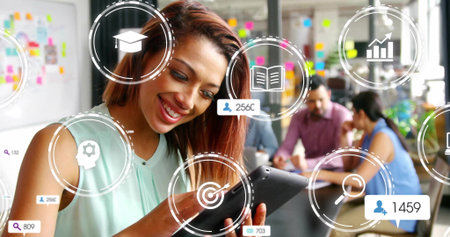 Mature woman in mint top tapping tablet in workspace, with sticky notes and augmented icons. Collaboration, brainstorming, innovation, teamwork, productivity, modernoffice, digitaltoolsの写真素材